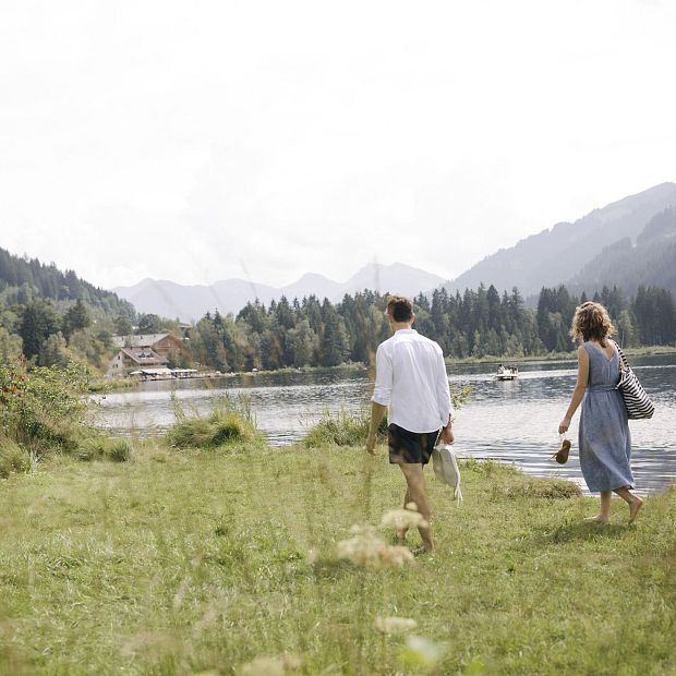 Paar beim Schwimmen in Kitzbühel. Auf den Weg in der Wiese zum See